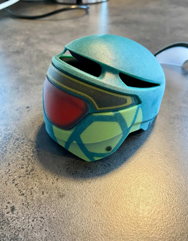 3D-printed Envoy helmet with a red visor on a desk 3D-printed Envoy helmet with a red visor on a desk