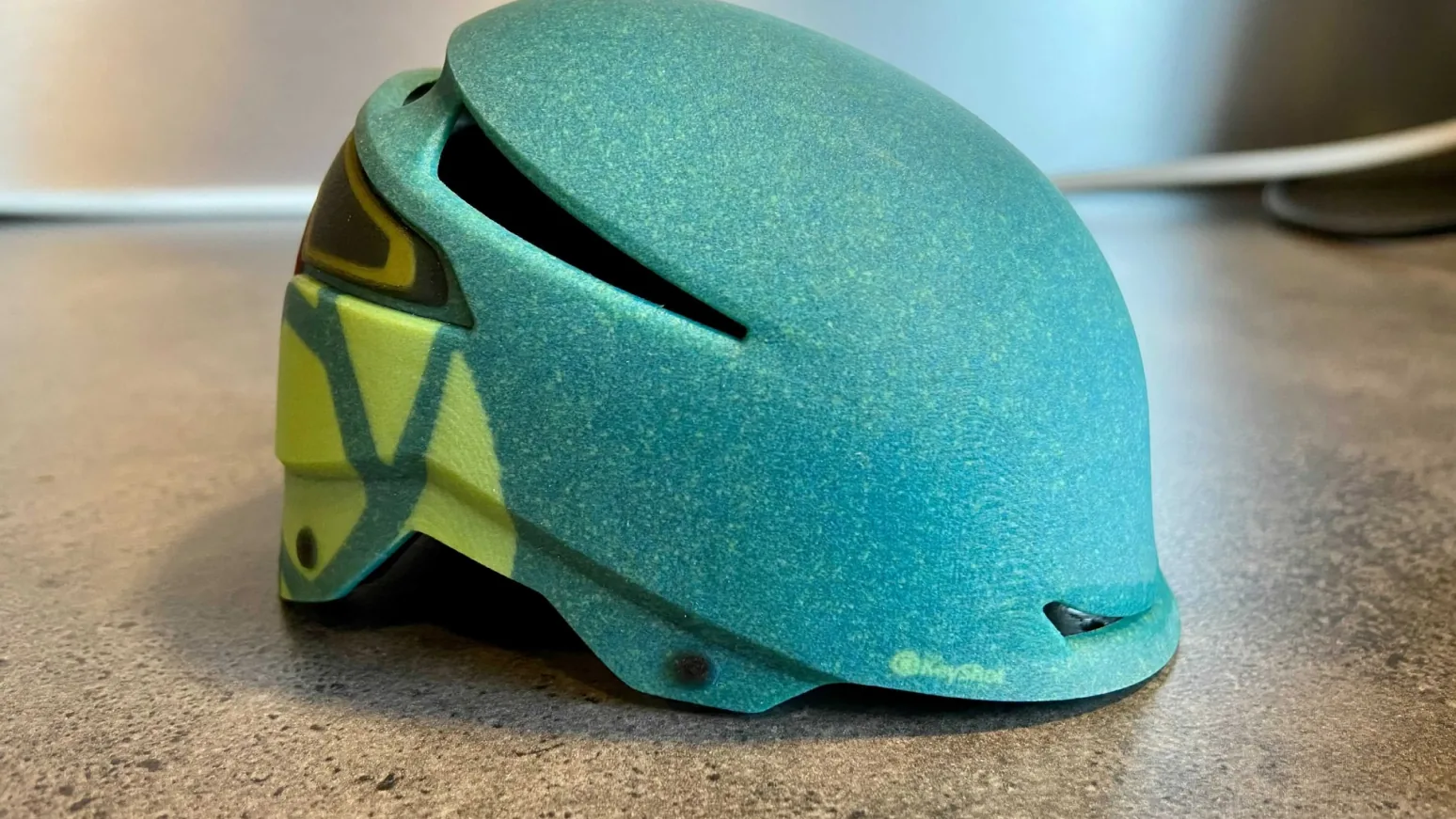 3D-printed Envoy helmet with a teal speckled shell on a concrete counter 3D-printed Envoy helmet with a teal speckled shell on a concrete counter